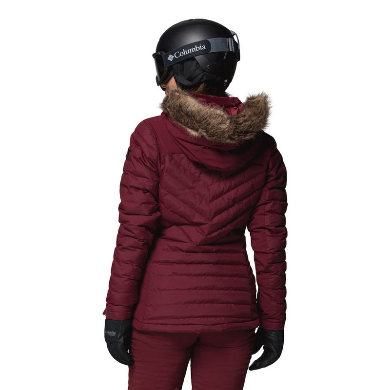 Load image into Gallery viewer, Person wearing a maroon winter jacket with fur hood and Columbia helmet on a white background
