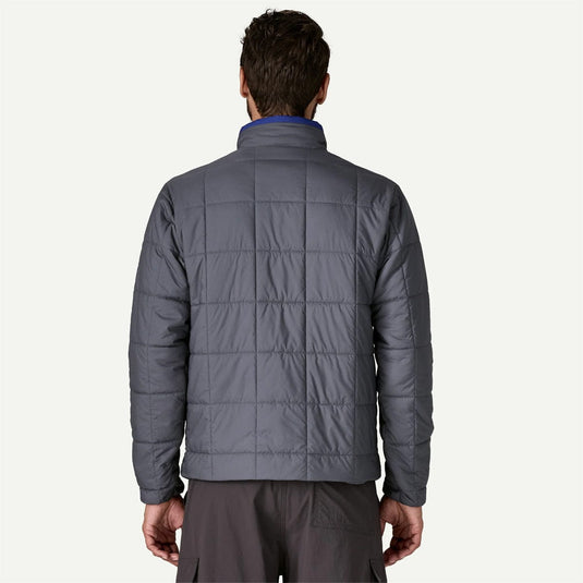 Person wearing a gray quilted jacket on a white background