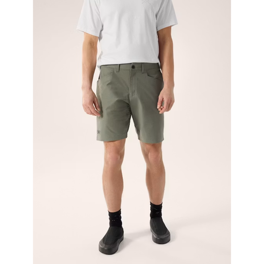 Person wearing olive green shorts on a white background