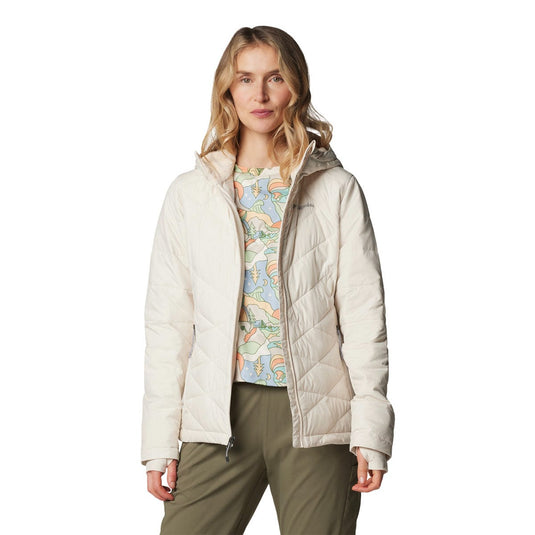 Woman wearing a beige puffer jacket over a colorful shirt on a white background