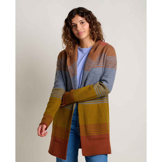 Woman wearing a colorful striped cardigan on a plain background