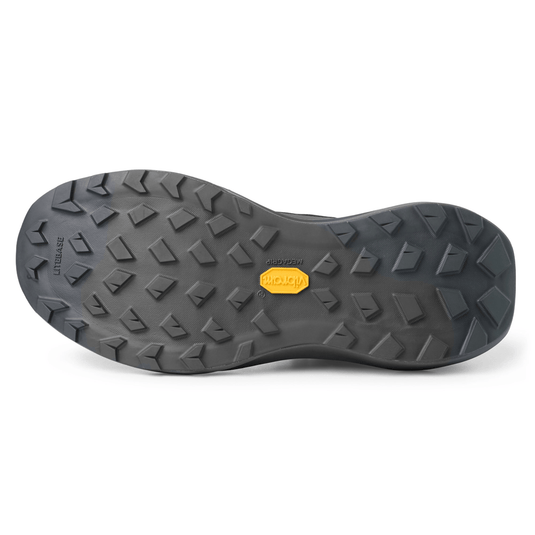 Close-up of a black shoe sole with a brand logo on a white background