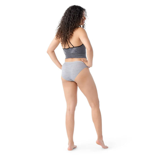 Woman wearing a gray bikini set on a white background