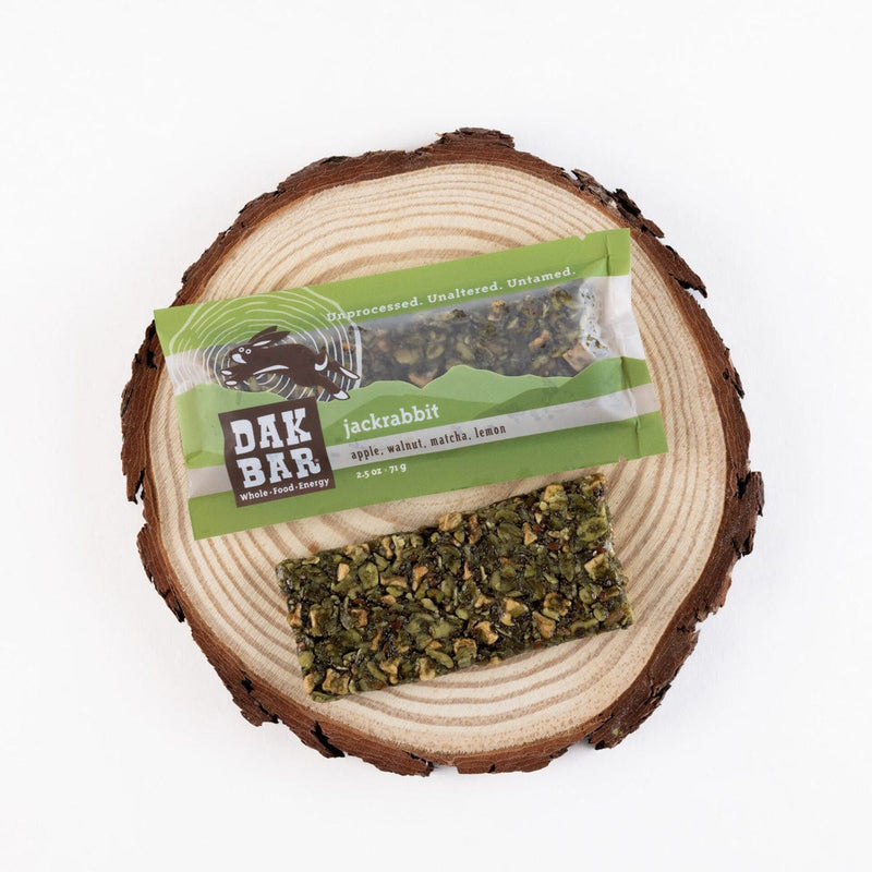 Load image into Gallery viewer, Dak Bar jackrabbit snack bar on a wooden log with a white background
