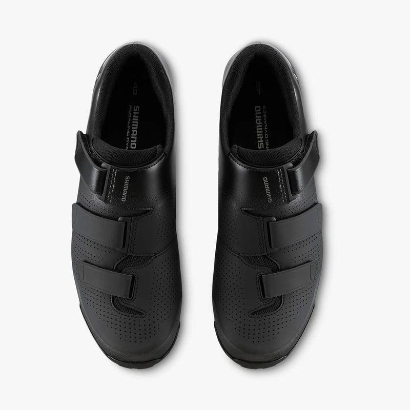 Load image into Gallery viewer, Pair of black cycling shoes with velcro straps on a white background
