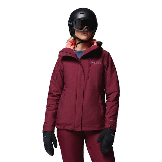 Person wearing a maroon ski jacket, pants, gloves, and helmet on a white background